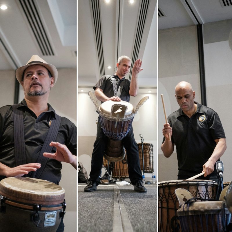 Three Drum Cafe facilitators playing djembes